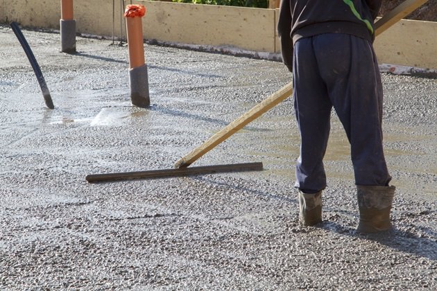 Faded and damaged stamped concrete patio being restored to original appearance