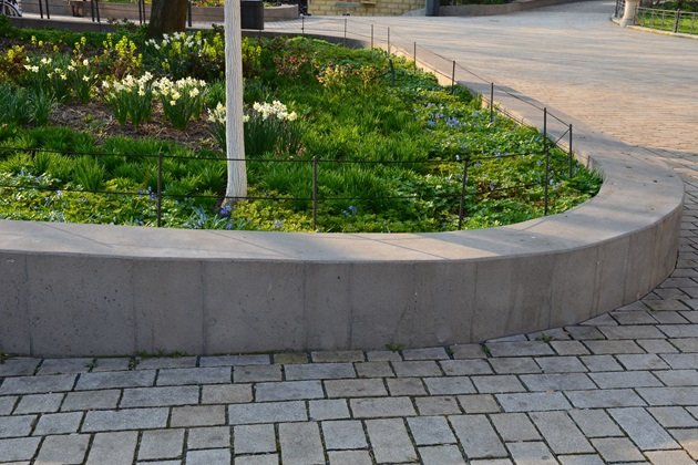 Modern concrete retaining wall with a smooth, sleek finish in a residential backyard